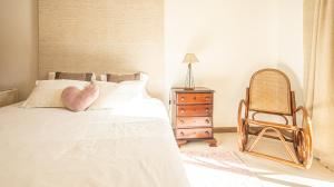 a bedroom with a bed with a chair and a dresser at Place in the sun - Free out door Jacuzzi - BY BEDZY in Albufeira
