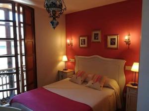 a bedroom with a white bed with red walls at HOTEL RURAL OSCOS in Villanueva de Oscos