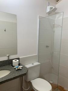 a bathroom with a toilet and a glass shower at Almas gêmeas quarto casal in Angra dos Reis