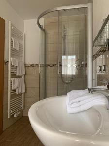 a bathroom with a tub and a glass shower at Hocher Hotel in Rothenburg ob der Tauber