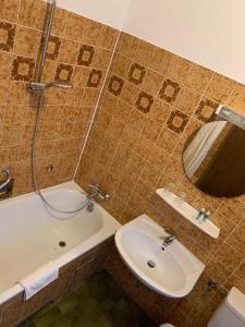 ein Badezimmer mit einem Waschbecken, einer Badewanne und einem WC in der Unterkunft Hocher Hotel in Rothenburg ob der Tauber