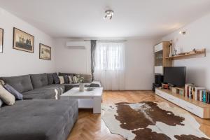 a living room with a couch and a tv at Boban Sunny Apartment in Solin