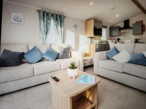 uma sala de estar com um sofá e uma mesa em 32 Bayview Oceans Edge em Morecambe