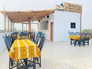 a row of tables and chairs with yellow table cloth at GRACE LODGE in Lomé