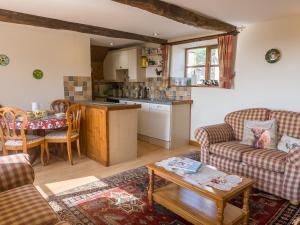 a living room with two couches and a kitchen at Frankaborough Farm Holiday Cottages in Virginstow