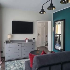 Apartment Secret في جونافا: غرفة معيشة مع أريكة وتلفزيون على الحائط