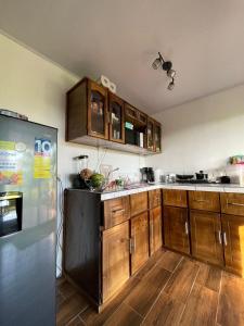 a kitchen with wooden cabinets and a refrigerator at Casa Lapa Delicias in Montezuma