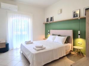 Un dormitorio con una cama grande con una pared verde. en Anna & Zampia central apts, en Kissamos