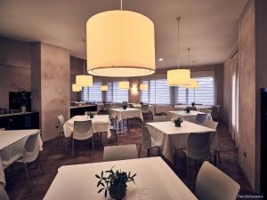 a restaurant with white tables and chairs and lights at Hotel Rural Casa Pernías in Moratalla