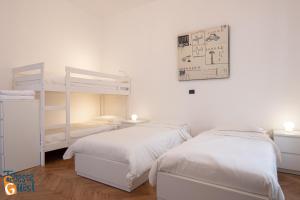 - 2 lits dans une chambre aux murs blancs dans l'établissement Gracie's Getaway x6, à Trieste
