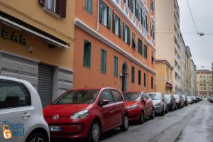 Une rangée de voitures garées dans une rue à côté des bâtiments dans l'établissement Gracie's Getaway x6, à Trieste