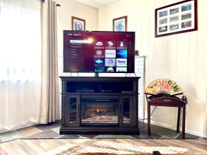 a tv on top of a fireplace in a living room at Sierra Sunset Cottage -Yosemite area vacation cottage in Ahwahnee