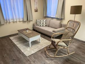 ein Wohnzimmer mit einem Sofa, einem Stuhl und einem Couchtisch in der Unterkunft Gemütliche Wohnung in Velden! in Velden am Wörthersee