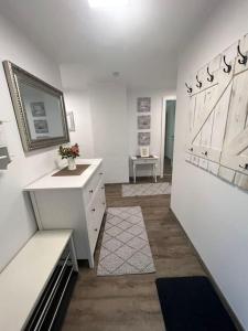 Dieses weiße Zimmer verfügt über einen Schreibtisch und eine Kommode. in der Unterkunft Gemütliche Wohnung in Velden! in Velden am Wörthersee