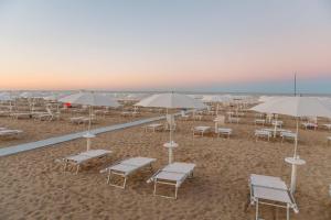 - un groupe de chaises longues et de parasols sur une plage dans l'établissement Trieste - Con servizio spiaggia - Narramondo Villas, à Giulianova