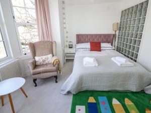 a bedroom with a large bed and a chair at 112 Balmoral Road in Morecambe