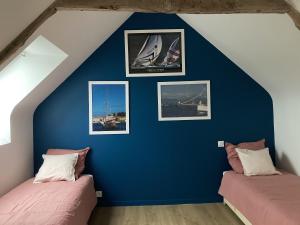 2 Betten in einem Zimmer mit blauer Wand in der Unterkunft Maison de 4 chambres avec jardin clos a Saint Cast le Guildo a 1 km de la plage in Saint-Cast-le-Guildo