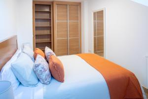 um quarto com uma cama branca com almofadas em Apartamento Solpor Bueu em Bueu
