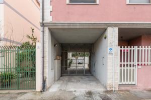 uma entrada para um edifício cor-de-rosa com um portão em poetto Quartu em Quartu SantʼElena
