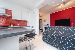 uma cozinha com uma parede vermelha, um lavatório e um balcão em poetto Quartu em Quartu SantʼElena