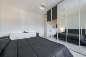 1 dormitorio con 1 cama grande y paredes de espejo en poetto Quartu en Quartu SantʼElena