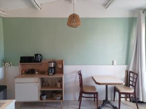 uma cozinha com uma mesa e duas cadeiras e uma mesa e um candeeiro em 4-Gîte 4 personnes avec piscine em Saint-Aubin-de-Nabirat