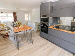 a kitchen with a wooden table and a counter top at 1 Gloucester Way in Pembroke Dock
