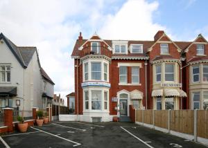 a house with a parking lot in front of it at Sandbanks Suite in Blackpool