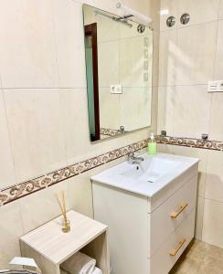een badkamer met een wastafel en een spiegel bij Apartamento Playa Blanca in Corcubión