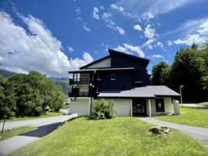 una casa en blanco y negro con césped verde en Studio moderne de 18m2 aux carroz d'arâches, en Les Carroz d'Araches