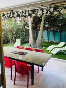 a table with red chairs and a sculpture of a tiger at 3 pièces terrasse, jardin in Cannes