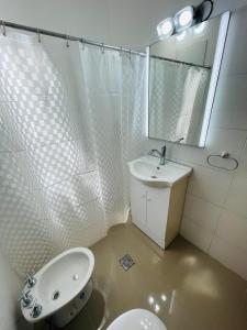 y baño con lavabo, aseo y espejo. en Departamento Dalmacio en La Rioja