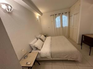 a bedroom with a bed and a table and a window at Keur RAMYBĖ in Sali Nianiaral +49 photos