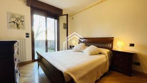 ein Schlafzimmer mit einem Bett und einem großen Fenster in der Unterkunft Villa Felice in San Felice del Benaco