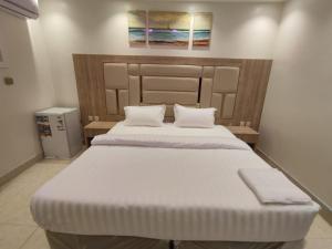 a bedroom with a large white bed with two pillows at ديار الفارس in Yanbu