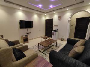 a living room with two couches and a tv at ديار الفارس in Yanbu