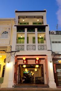 un edificio blanco con balcón en la parte superior en 99 Oldtown Boutique Guesthouse SHA EXTRA PLUS, en Phuket