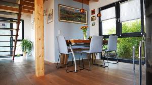 a dining room with a wooden table and chairs at FERIENHAUS am HAINER SEE in Neukieritzsch