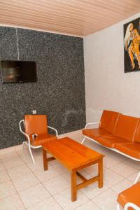 een woonkamer met een oranje bank en een tafel bij Auberge La Caverne in Kigali