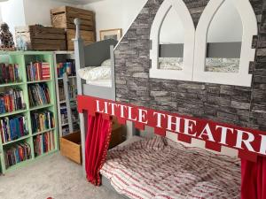 a little theatre room with a bed and bookshelves at Chapel Theatre House in Sandgate