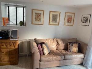 a living room with a brown couch and a table at Chapel Theatre House in Sandgate