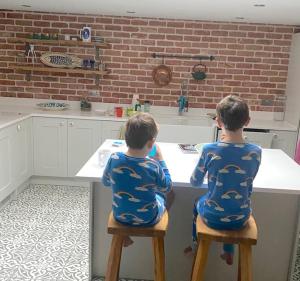 two young boys sitting on stools at a kitchen counter at Chapel Theatre House in Sandgate