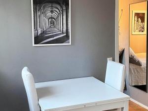 a white table and chairs in a room with a picture at Holiday home INGARÖ VI in Lillängsdal