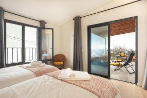 a bedroom with a bed and a large glass window at Referta Apartamento T1 in Prazeres