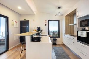 a kitchen with white cabinets and a counter top at Referta Apartamento T1 in Prazeres