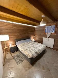 um quarto com uma cama num quarto com paredes de madeira em Tabia Suite Pelmo em Villagrande