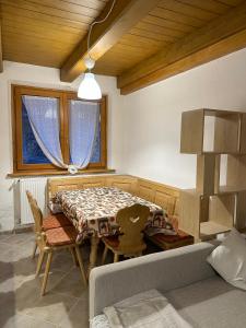 uma sala de jantar com uma mesa e um sofá em Tabia Suite Pelmo em Villagrande