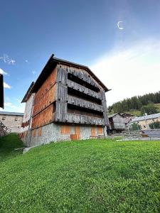 an old building sitting on top of a grass field at Tabia Suite Pelmo in Villagrande +7 photos