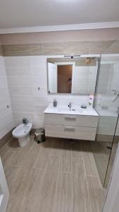 a bathroom with a sink and a toilet and a mirror at CASA LORY in Playa Blanca