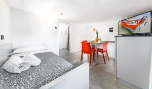 una camera da letto con un letto e un tavolo con sedie di Mini Suite (3 adulti) a Riccione Altre 2 foto